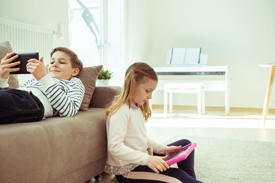 Siblings using technologies at home
