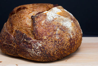 Close-up of bread on table against black background