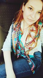 Portrait of smiling young woman sitting outdoors