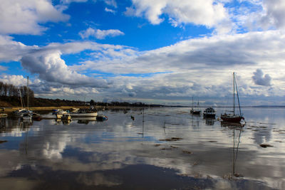 Boats moored in lake against sky