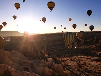 Hot air balloons flying over landscape against sky