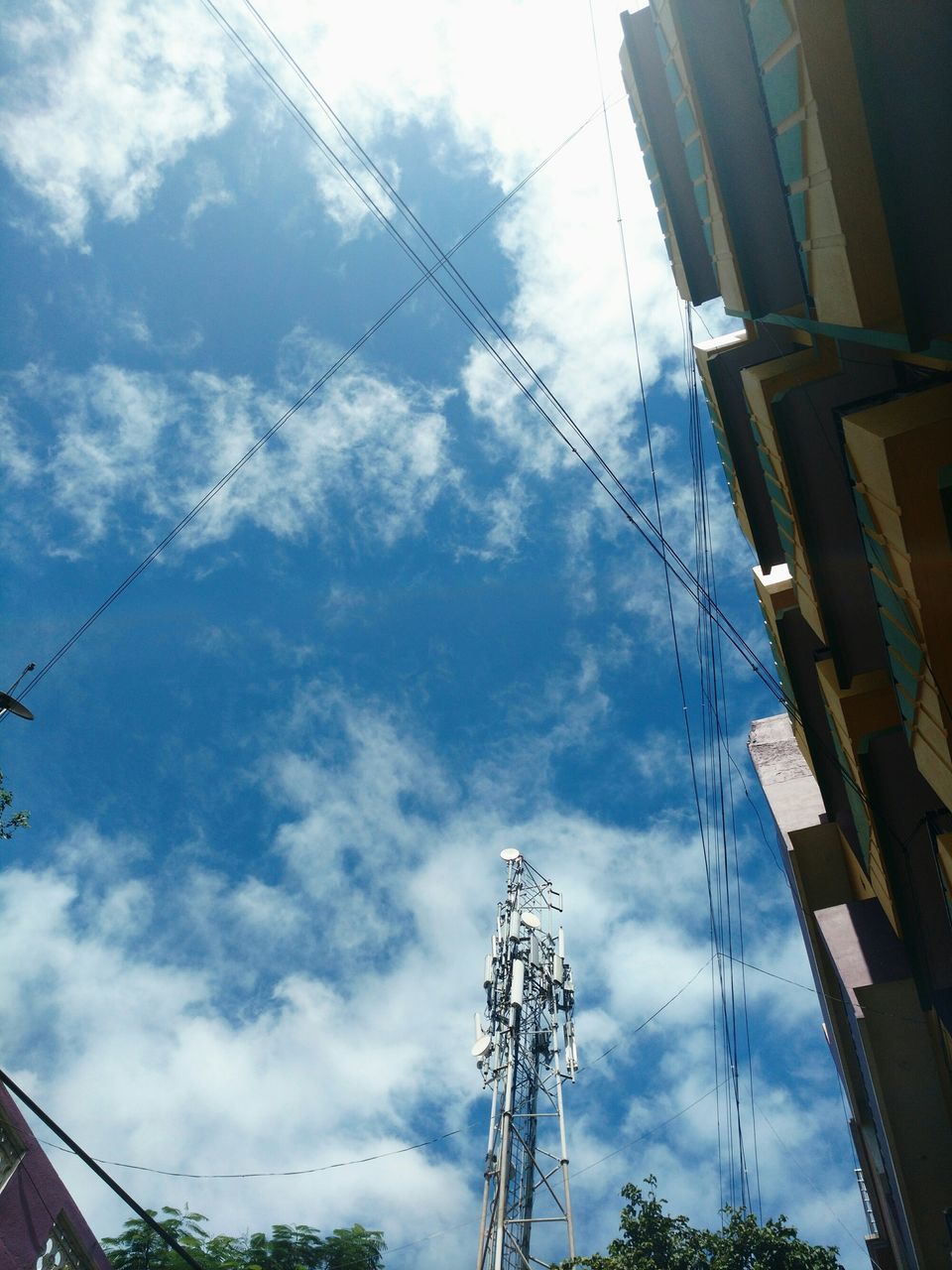 low angle view, sky, built structure, architecture, building exterior, cloud - sky, power line, electricity pylon, cloudy, electricity, cable, power supply, cloud, connection, technology, fuel and power generation, day, building, outdoors, crane - construction machinery