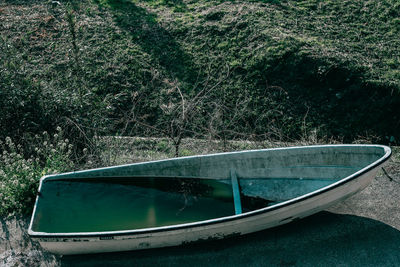 High angle view of boat filled with water moored by field