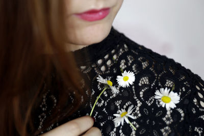 Close-up of woman holding flowering plant