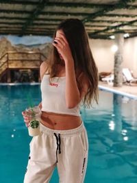 Woman drinking water in swimming pool