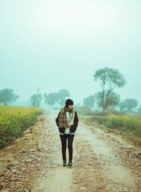 Full length of man standing on road amidst trees