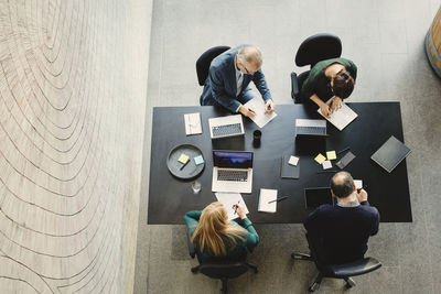 High angle view of multi-ethnic business people working at table in creative office