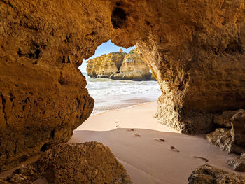 Direct view through hole exit of rock formations on beach