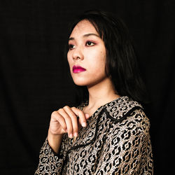 Portrait of a beautiful young woman over black background