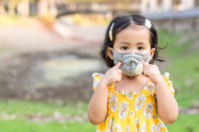 Cute girl standing outdoor wearing medical face mask to prevent flu, pollution and covid 19.