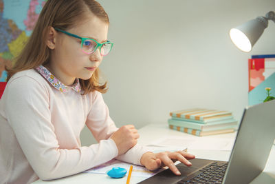 Cute girl using laptop at home