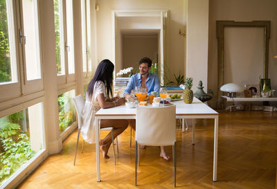 Friends sitting on table at home