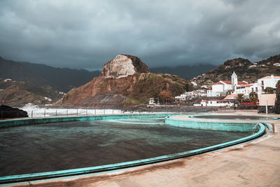 View of swimming pool against cloudy sky