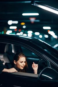 Happy young woman sitting in car