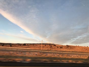 Scenic view of road on field against sky