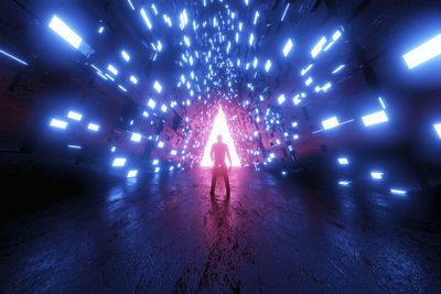 Man in illuminated tunnel at night