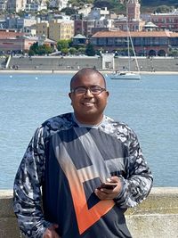 Portrait of smiling man standing by sea