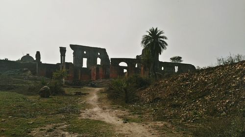 Abandoned built structure on landscape against clear sky