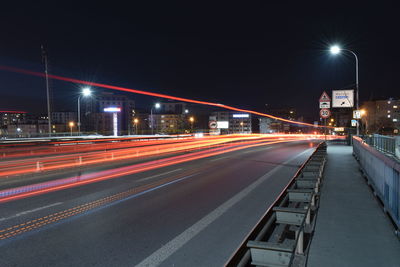 Light trails on road against sky at night