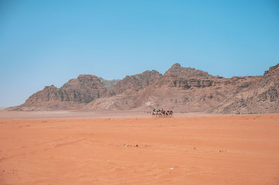 Scenic view of desert against clear blue sky