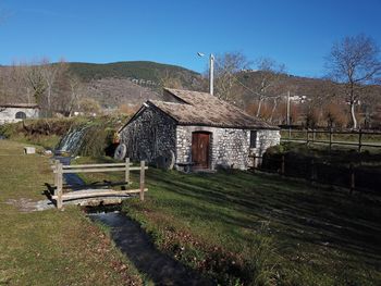 Houses by trees against clear sky
