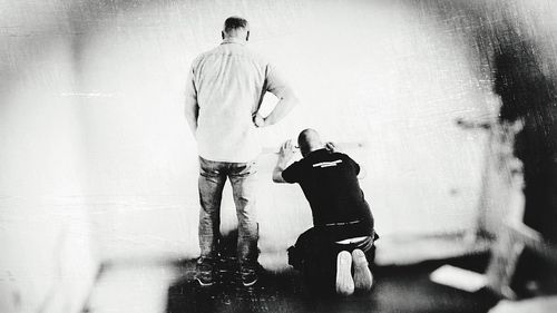 Rear view of shirtless man standing on floor