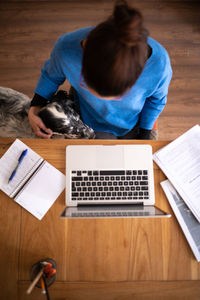 Midsection of woman using laptop at table