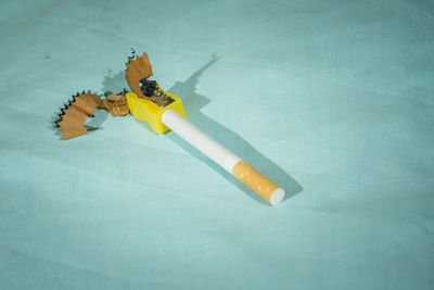 High angle view of cigarette on table against blue background