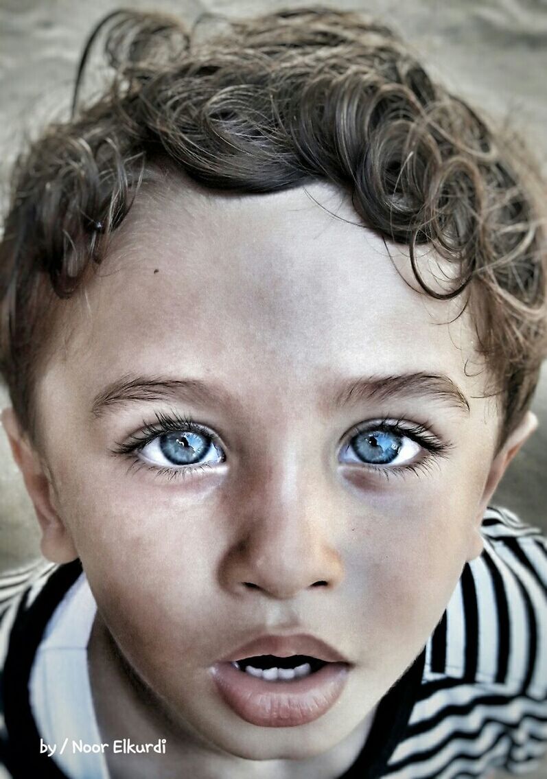 headshot, looking at camera, portrait, close-up, front view, person, innocence, black hair, focus on foreground, young adult, toddler