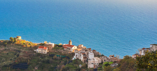 Buildings by sea against sky