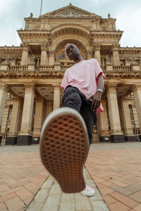 Rear view of woman against historic building