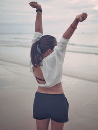 Full length of young woman standing at beach