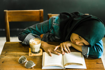 Midsection of man reading book on table