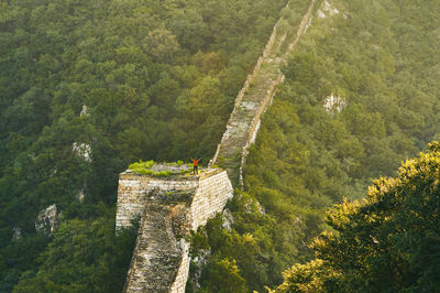 High angle view of man with arms raised while standing on great wall of china