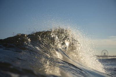 Water splashing in sea against clear sky