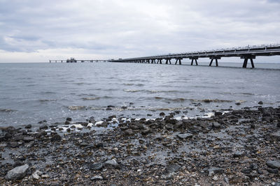 Bridge over sea against sky