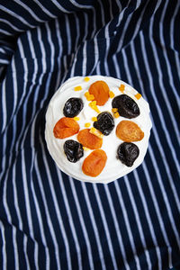 An easter cake decorated with dried apricots and prunes stands on a striped blue apron. 