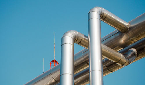 Low angle view of pipes against sky