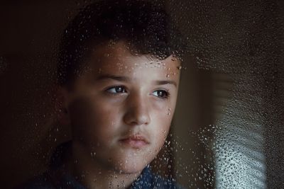 Close-up portrait of wet boy in rain