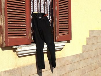 Full length of woman standing on staircase against wall