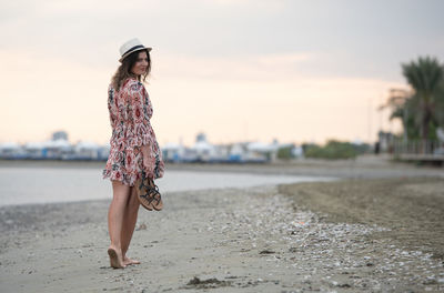 Portrait of young woman standing at beach