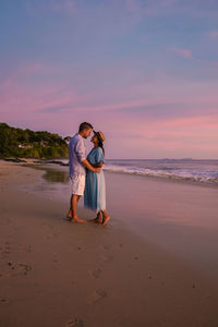 Couple kissing standing on beach