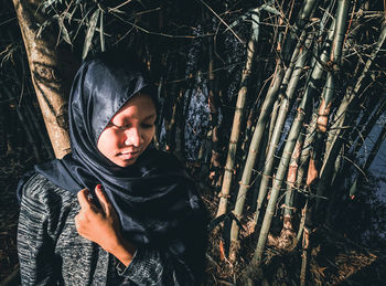 Close-up of girl standing amidst plant