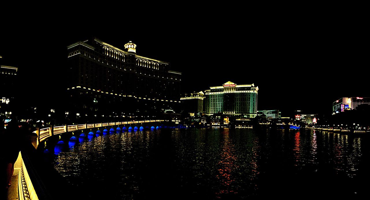 ILLUMINATED CITY BY RIVER AT NIGHT