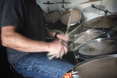 Midsection of man playing drum