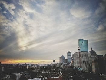 Skyscrapers in city at sunset