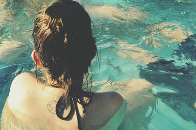 Rear view of woman swimming in pool