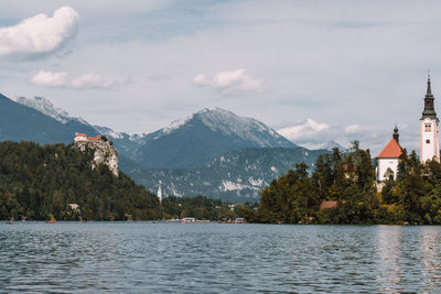 Scenic view of lake by mountains against sky