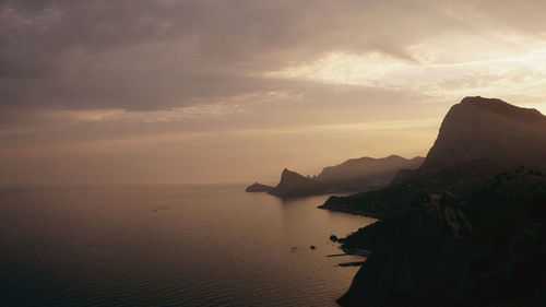 Scenic view of sea against cloudy sky during sunset