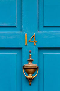 House number 14 on a blue wooden front door in london 